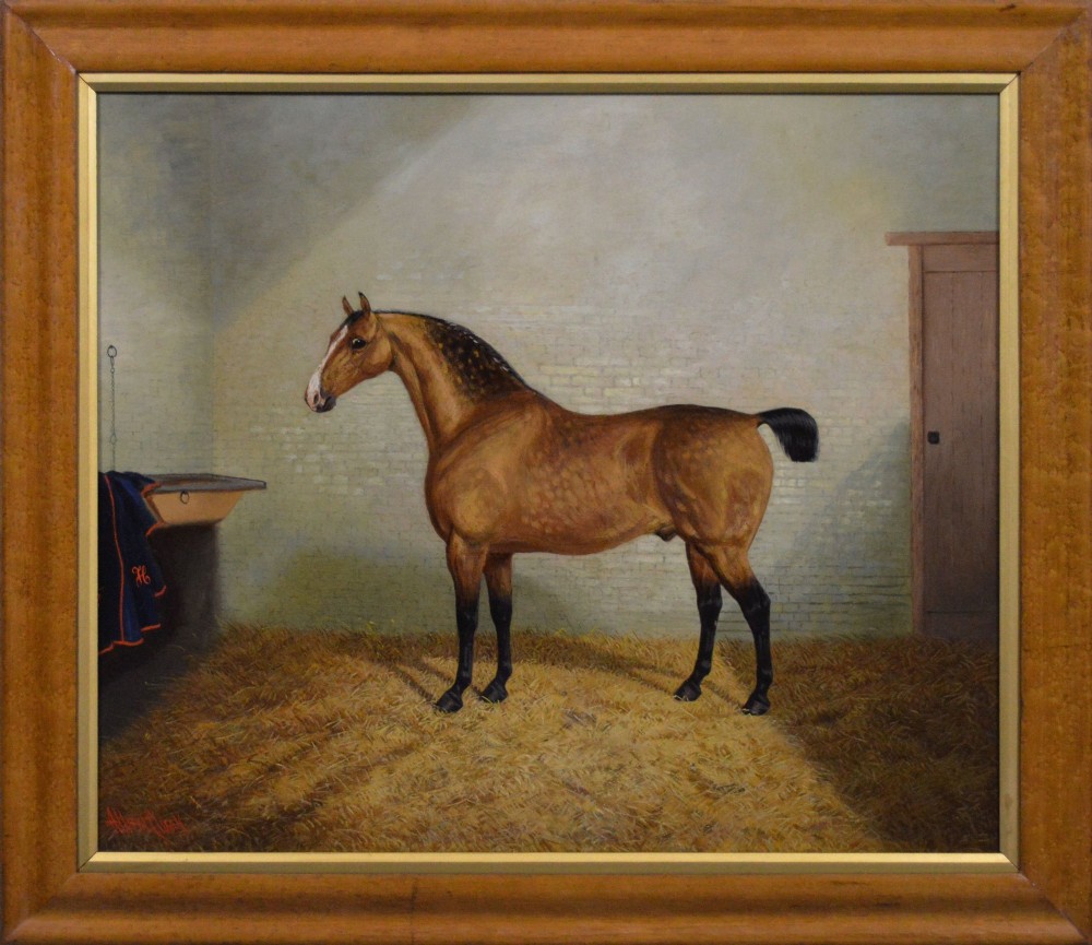A nineteenth-century oil painting featuring a dappled buckskin horse standing in profile inside a stable, framed by a timber surround with a gilt inner slip.