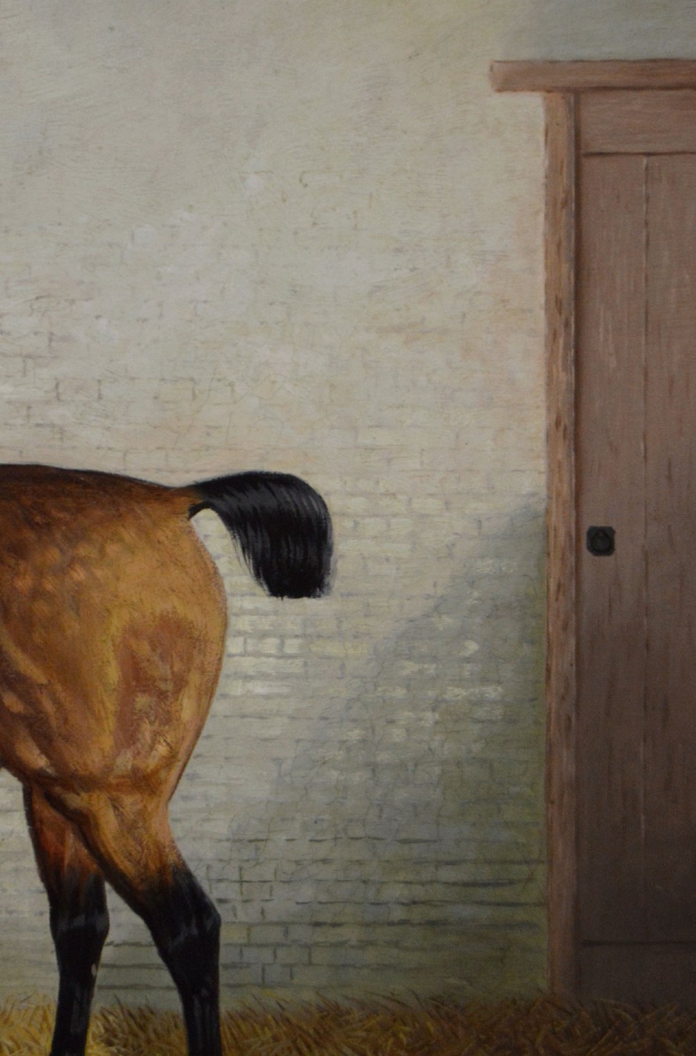 A nineteenth-century oil painting featuring a dappled buckskin horse standing in profile inside a stable, framed by a timber surround with a gilt inner slip. View V