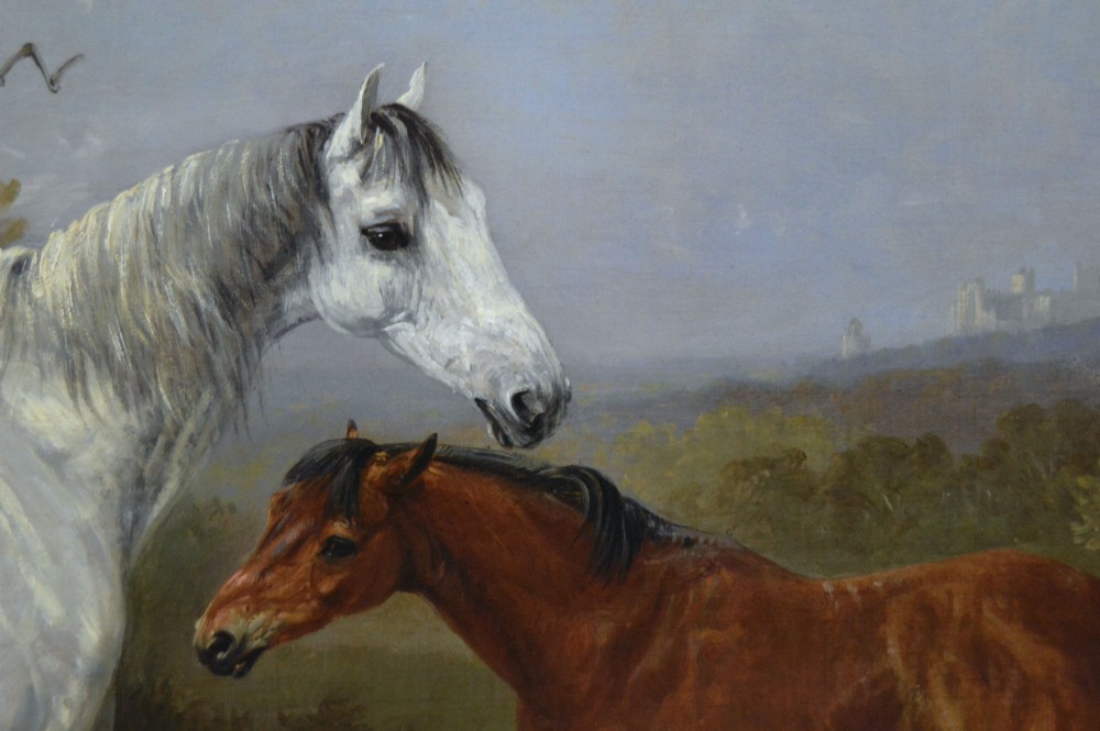 A 19th-century oil painting depicting a grey mare and a bay foal standing in a rural landscape with Windsor Castle in the distance, set within a beaded gold frame. View V