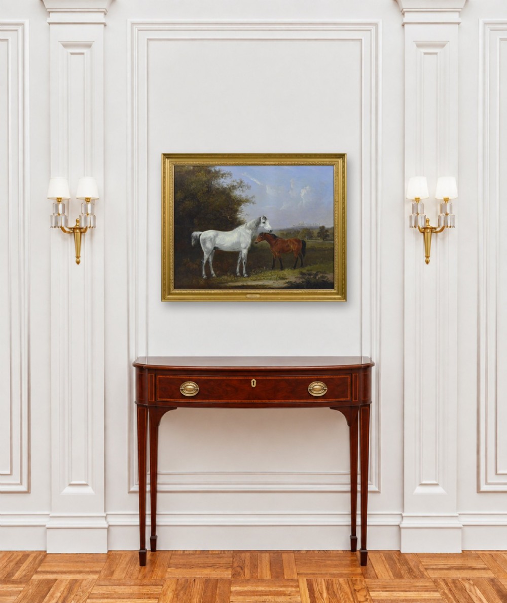 A 19th-century oil painting depicting a grey mare and a bay foal standing in a rural landscape with Windsor Castle in the distance, set within a beaded gold frame. View XI