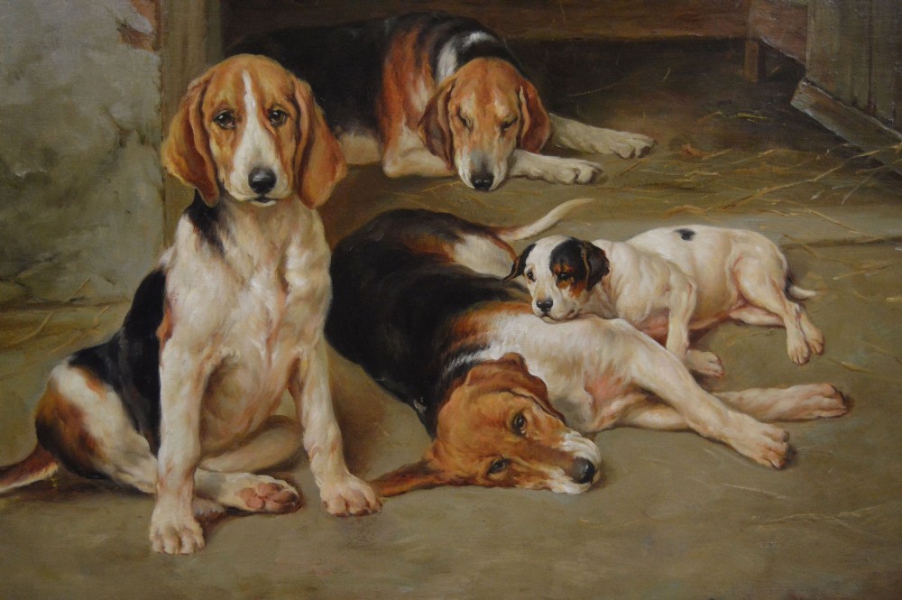 An oil painting depicting several foxhound puppies and a fox terrier resting on a barn floor, set within a heavy carved gilded frame. View IV