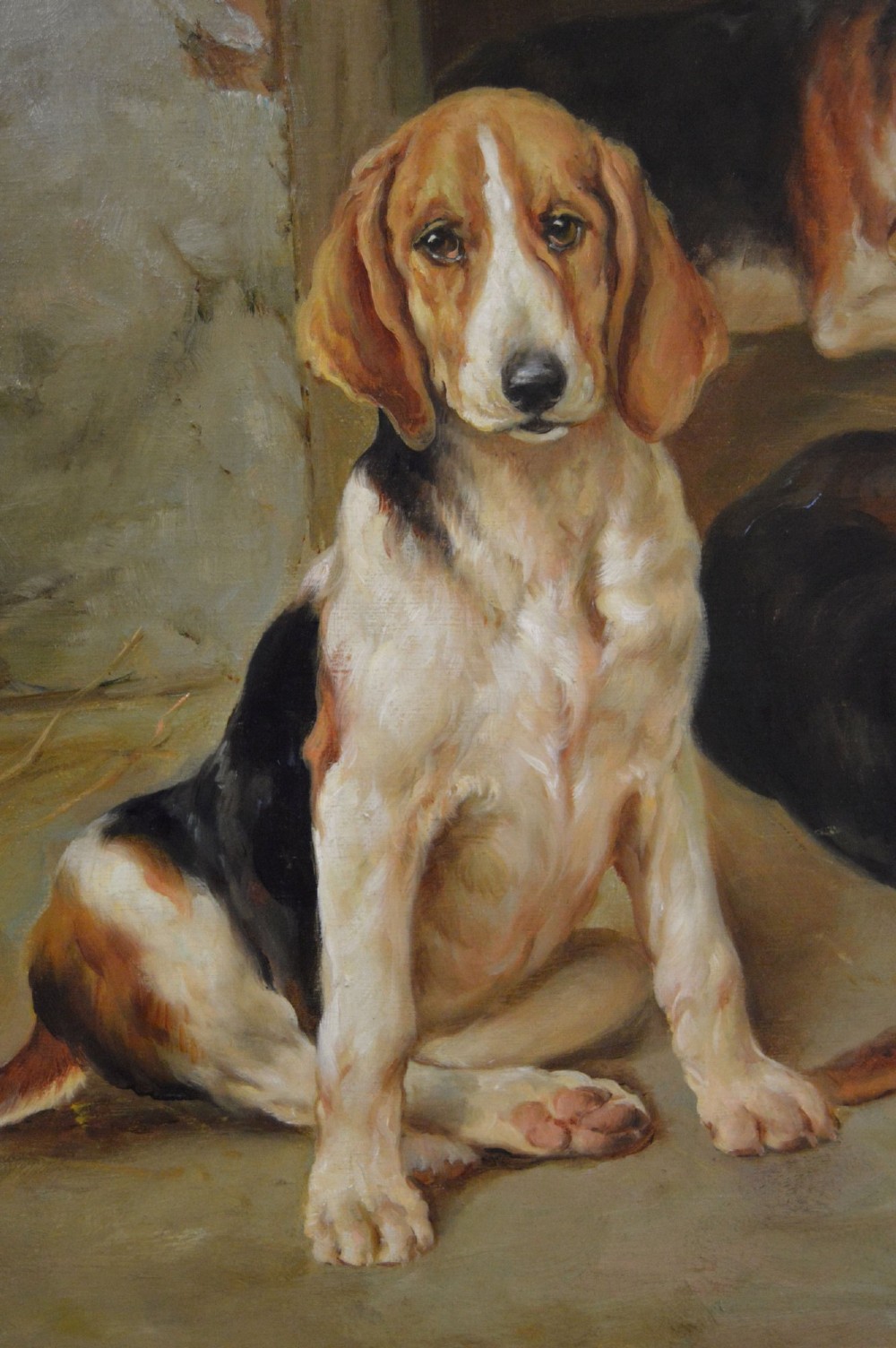 An oil painting depicting several foxhound puppies and a fox terrier resting on a barn floor, set within a heavy carved gilded frame. View V