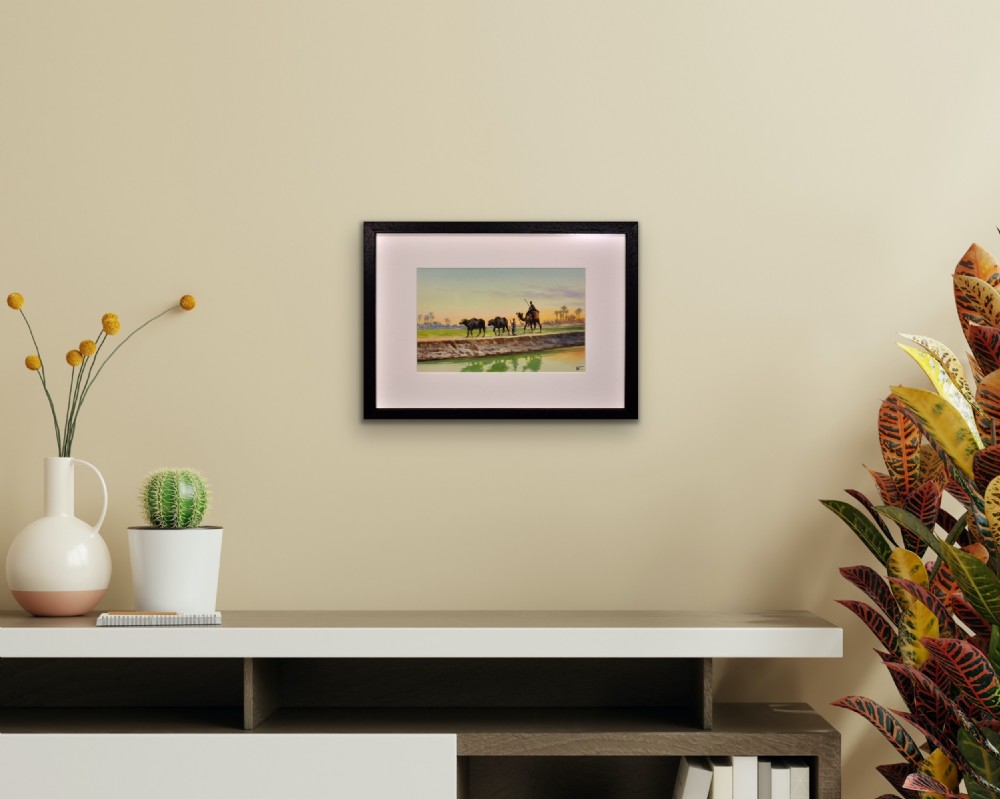 A framed watercolour painting depicting Egyptian farmers leading livestock and a rider on a camel along a canal bank at sunset. View X