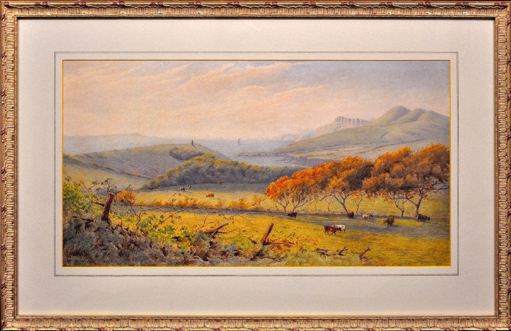 A framed Victorian watercolour painting depicting a sweeping coastal landscape in Dorset with cattle grazing in a field beneath a light sky.