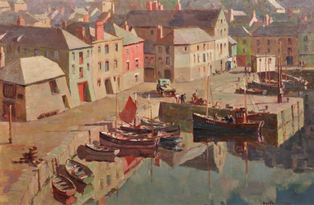A framed mid-century oil painting depicting a calm Cornish harbour with pastel-painted buildings and moored fishing boats reflected in the water. View II