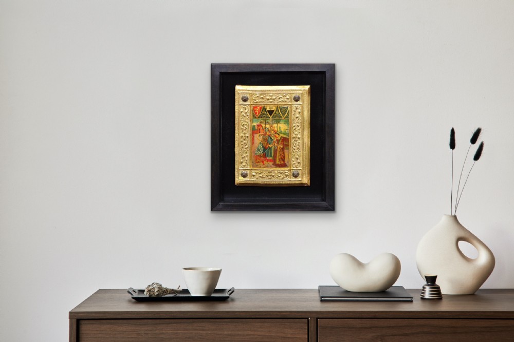 A framed gilded and painted wooden book cover panel featuring figures in Renaissance dress surrounded by embossed gold leaf borders and armorial crests. View XXIII