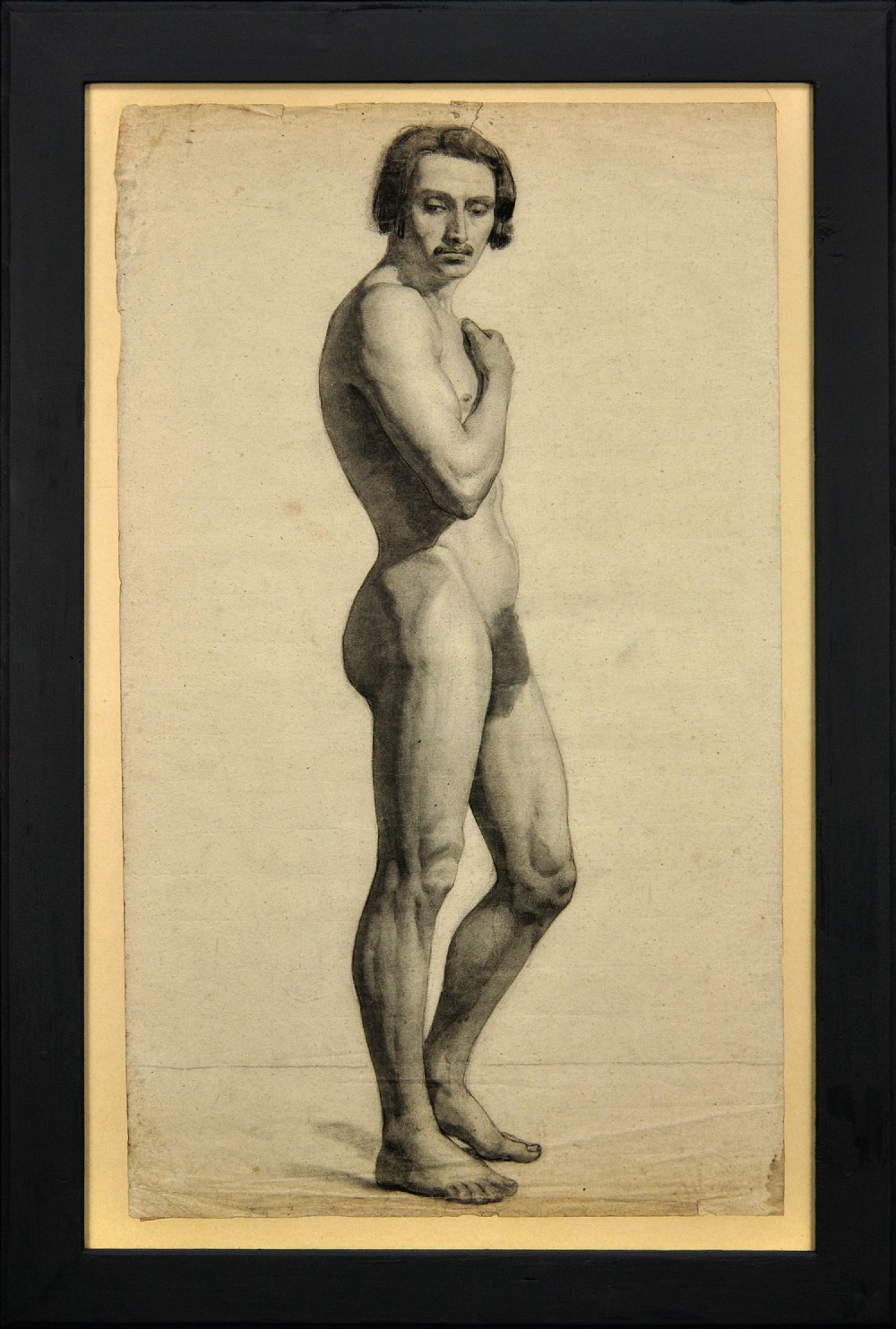 A framed mid-nineteenth-century charcoal drawing on paper depicting a standing male nude figure in profile.