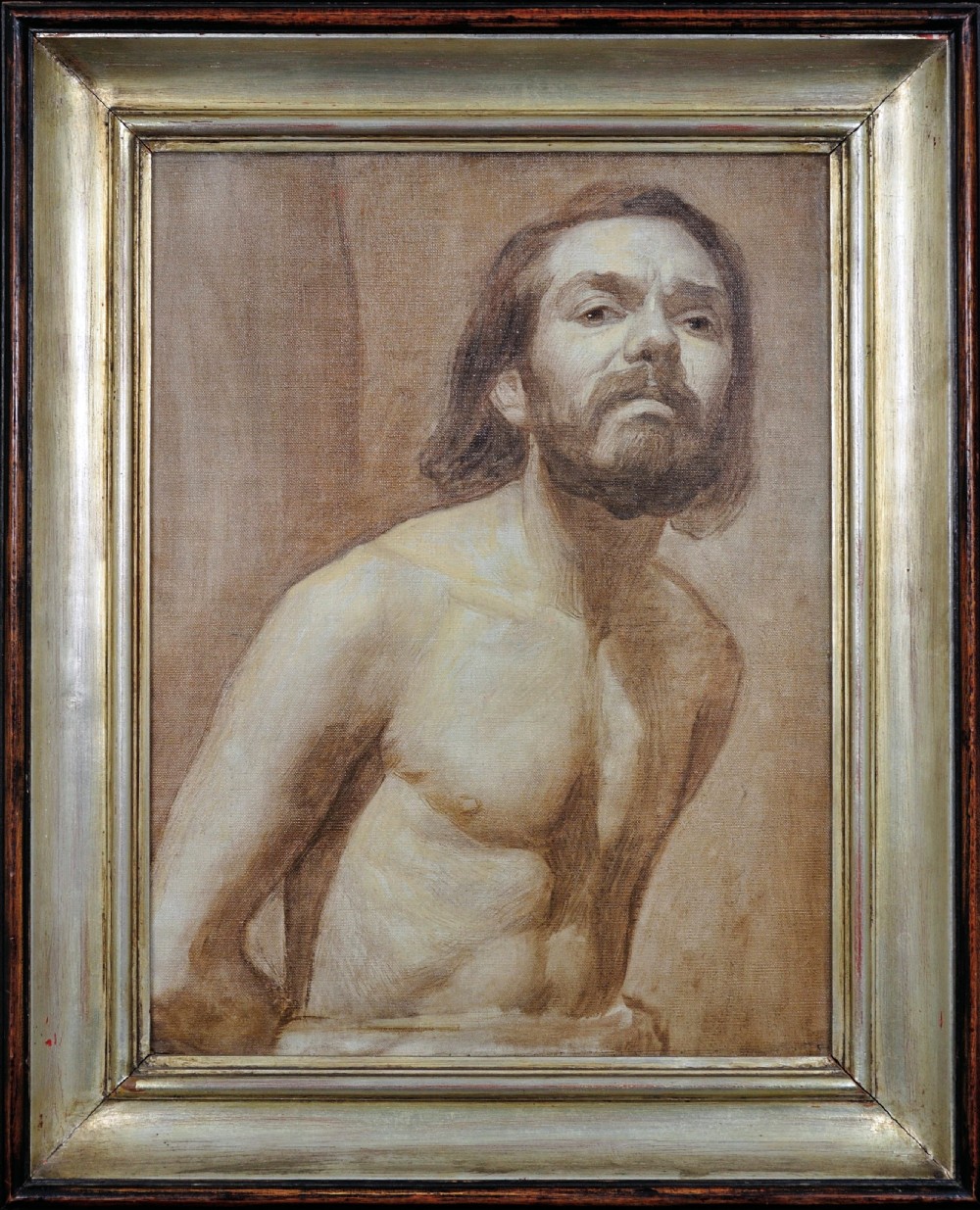 A framed monochrome oil painting depicting a three-quarter male nude self-portrait with a beard in a classical pose, housed within a moulded silver frame.