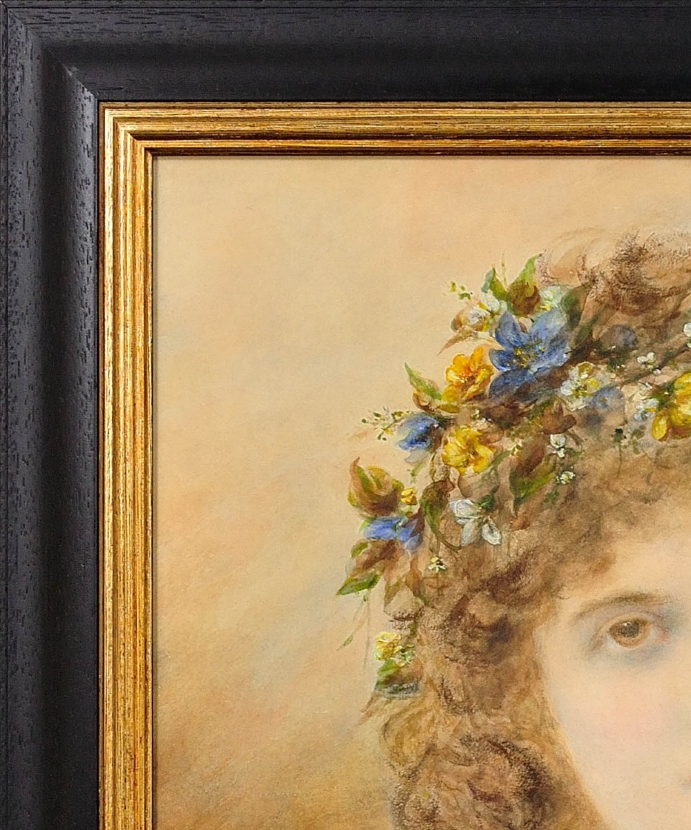 A framed Victorian watercolour and gouache portrait depicting a young woman with long cascading brown hair adorned with a crown of colorful spring flowers. View V