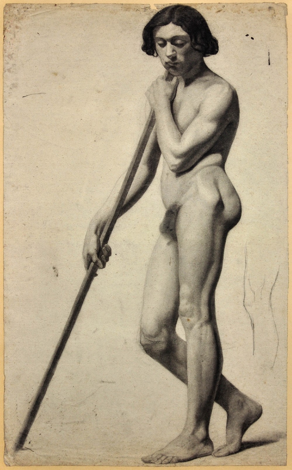A nineteenth-century framed charcoal drawing on light cream paper depicting a full-length standing male nude holding a long staff. View II