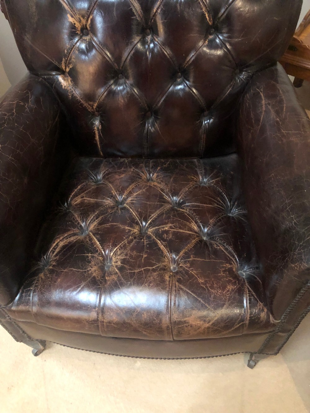 A pair of dark brown leather Edwardian club chairs featuring deep-buttoned backrests, brass stud trimming, and square tapered legs on castors. View IV