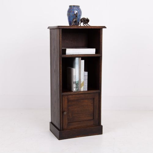 fig 1. A small late Victorian dark oak bookcase featuring two open shelves above a single cupboard door with carved rope-twist moulding and a solid plinth base.