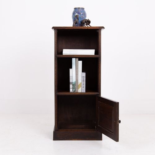 fig 2. A small late Victorian dark oak bookcase featuring two open shelves above a single cupboard door with carved rope-twist moulding and a solid plinth base.