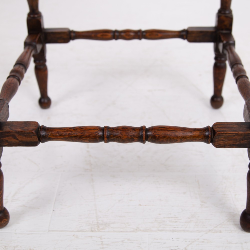 An antique dark oak side table featuring a single drawer with a brass drop ring pull, slender turned legs, and a bobbin stretcher base. View VIII