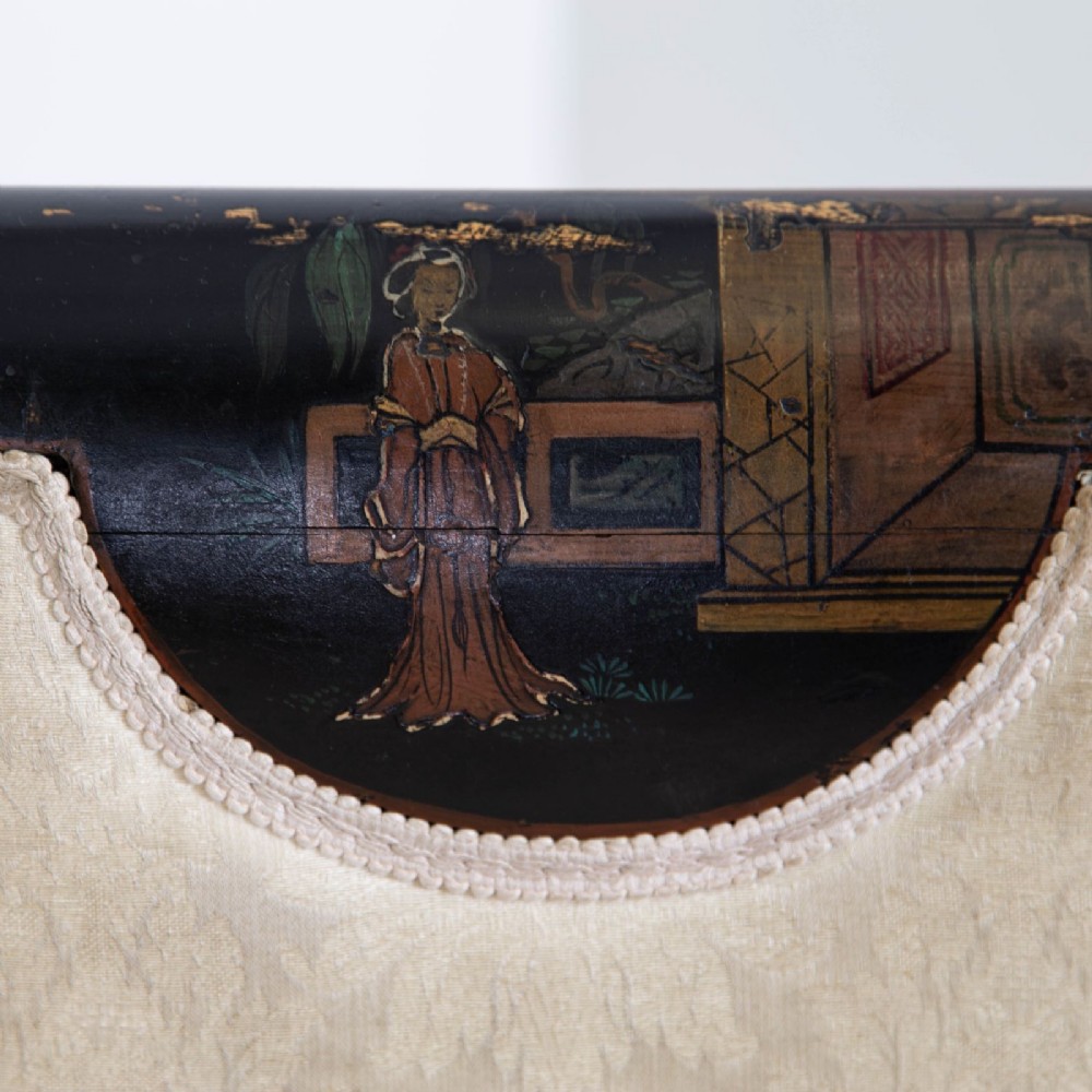 A Victorian Chinoiserie sofa with a black lacquered frame featuring gilt painted details, semicircular cream patterned back panels, and cream upholstered seat cushions. View V