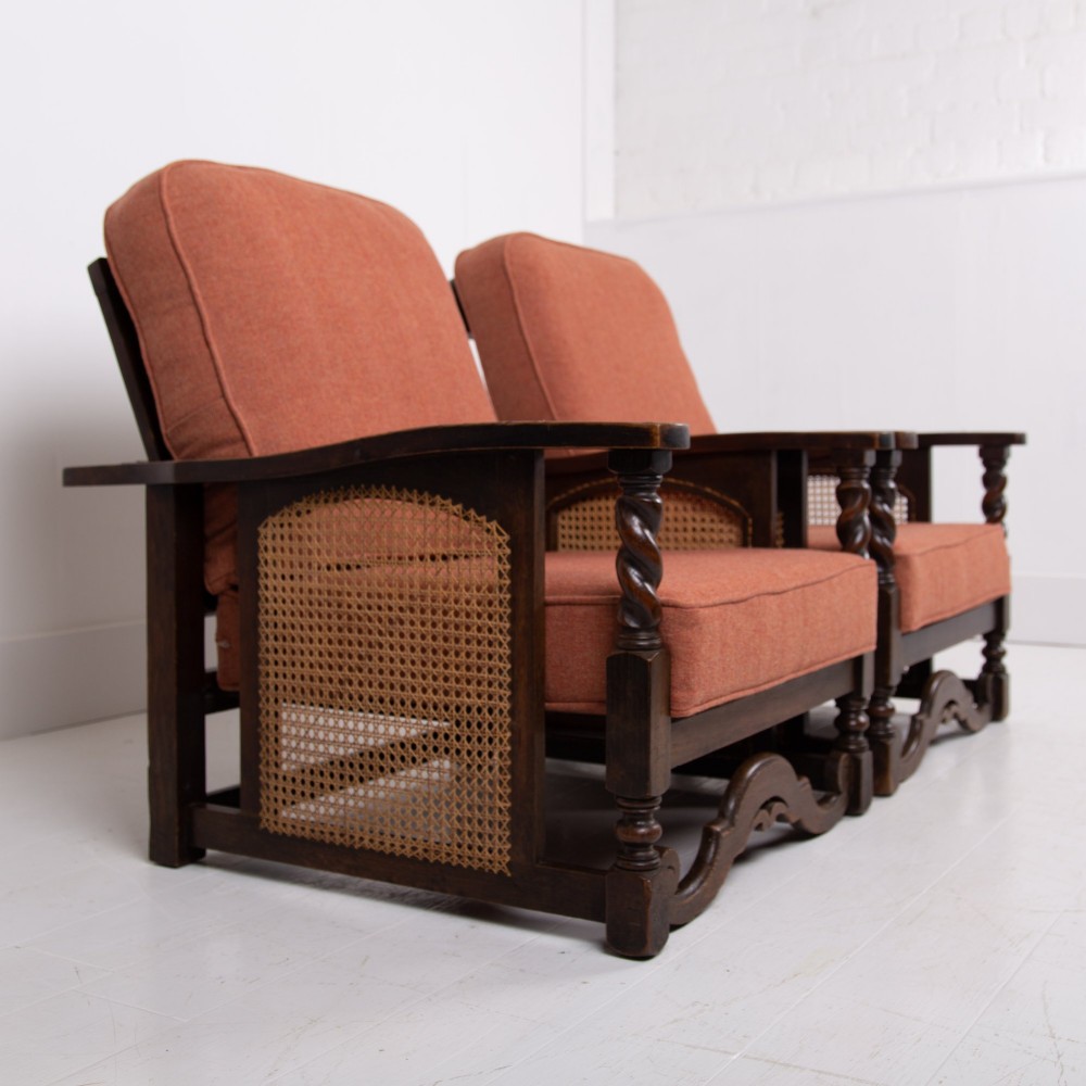 A pair of 1920s dark oak armchairs featuring barley twist supports, woven cane side panels, and terracotta upholstered cushions. View II