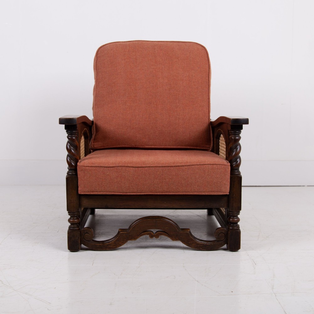 A pair of 1920s dark oak armchairs featuring barley twist supports, woven cane side panels, and terracotta upholstered cushions. View VI