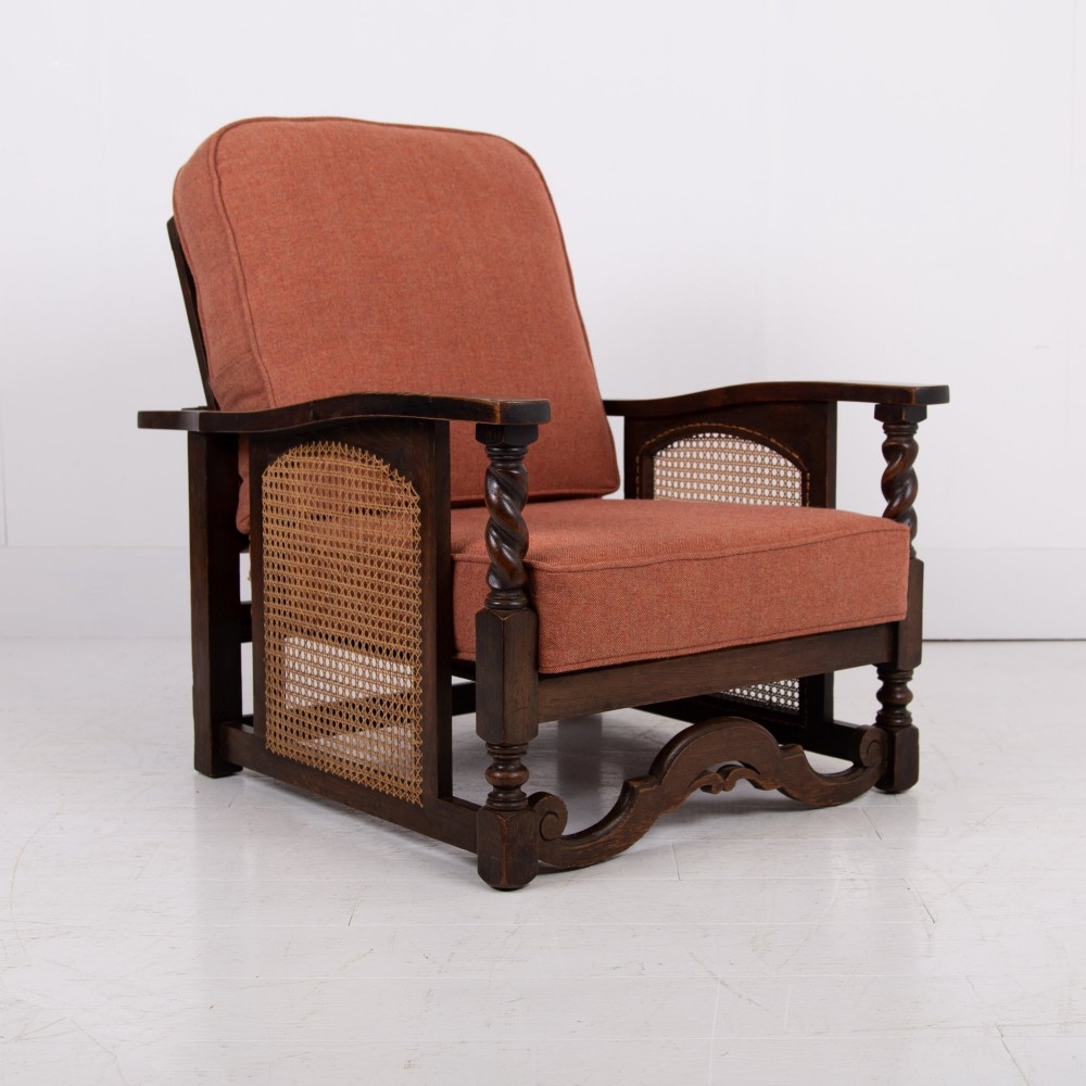 A pair of 1920s dark oak armchairs featuring barley twist supports, woven cane side panels, and terracotta upholstered cushions. View VII