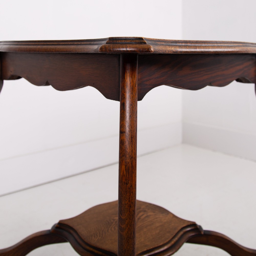 An Edwardian oak occasional table featuring a serpentine-shaped top surface, four slender cabriole legs, and a matching lower shelf. View VI
