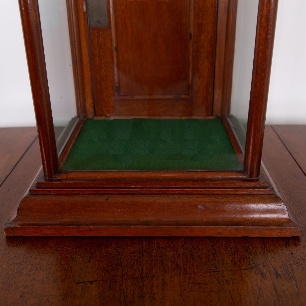 A vertical glazed tabletop display cabinet crafted from warm brown mahogany with glass side panels, turned columns, and a green felt-lined base. View V