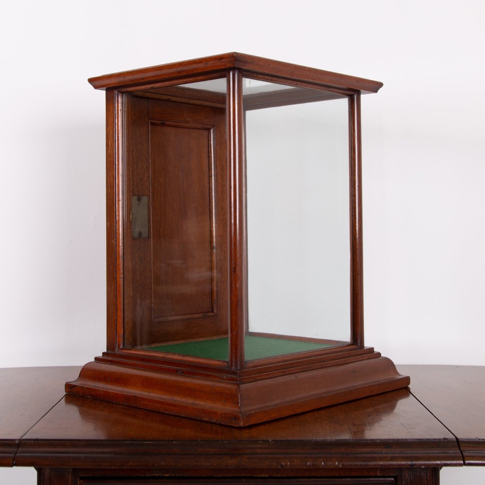 A vertical glazed tabletop display cabinet crafted from warm brown mahogany with glass side panels, turned columns, and a green felt-lined base. View XII