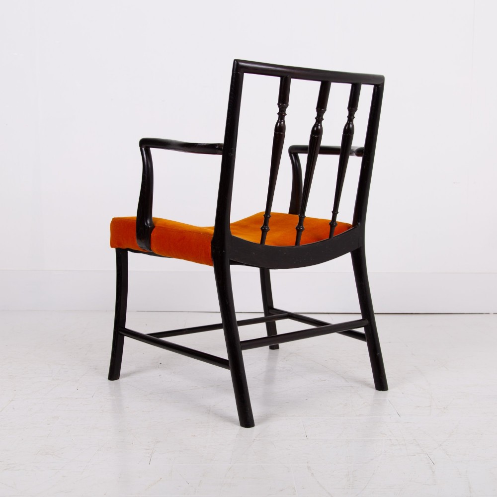 An ebonised wooden Cockpen armchair featuring a turned spindled backrest, curved armrests, and an orange velvet seat. View IV