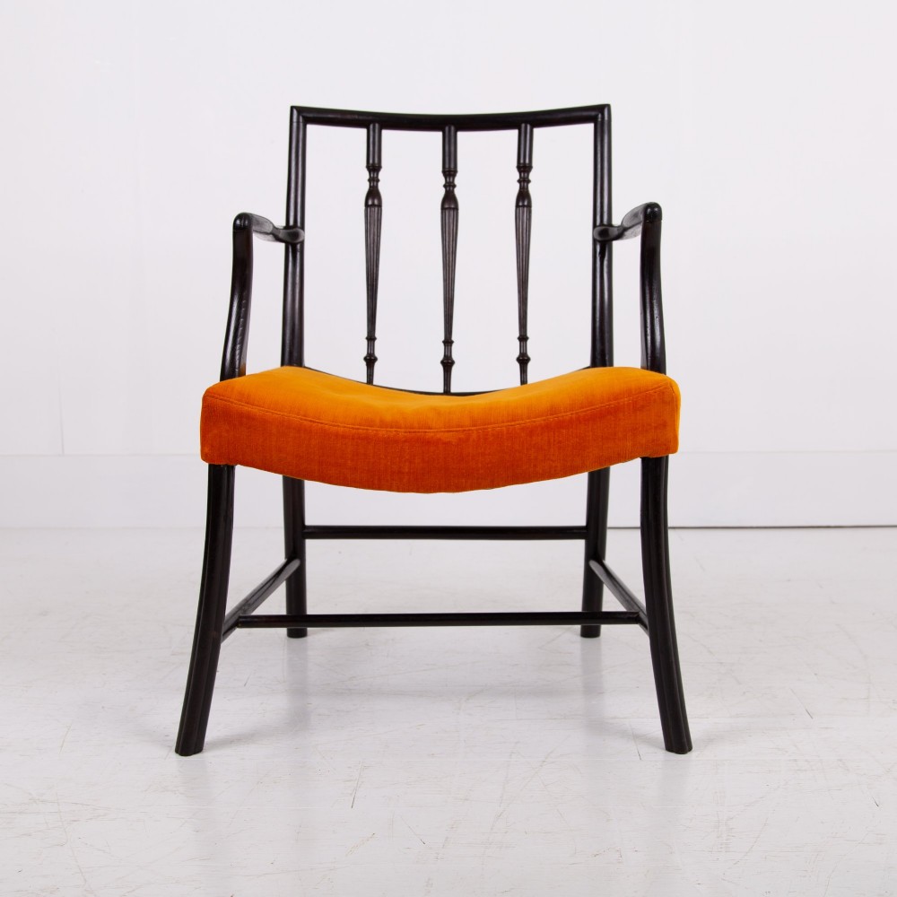 An ebonised wooden Cockpen armchair featuring a turned spindled backrest, curved armrests, and an orange velvet seat. View VII