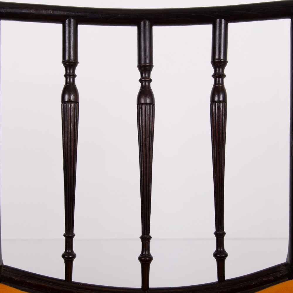An ebonised wooden Cockpen armchair featuring a turned spindled backrest, curved armrests, and an orange velvet seat. View XII