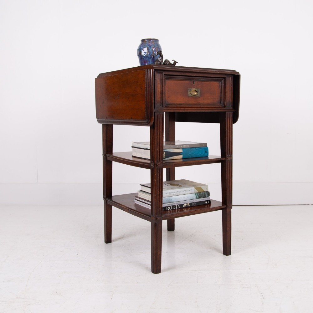 A late nineteenth-century dark mahogany drop-leaf table featuring a single top drawer with a brass pull, two lower open shelves, and fluted legs. View II