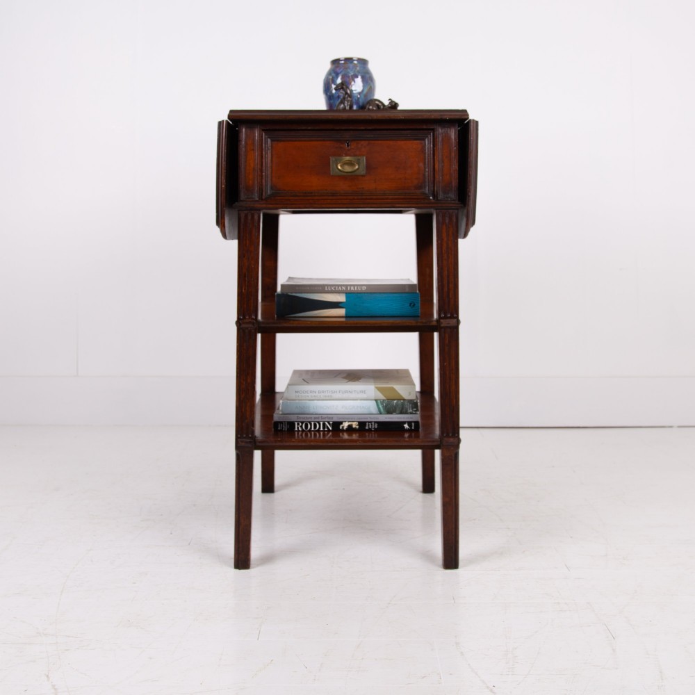 A late nineteenth-century dark mahogany drop-leaf table featuring a single top drawer with a brass pull, two lower open shelves, and fluted legs. View III