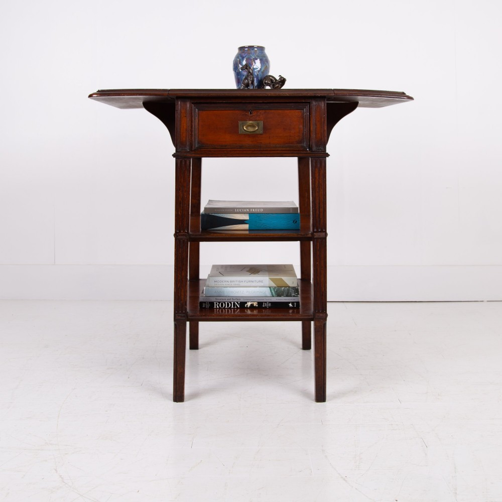 A late nineteenth-century dark mahogany drop-leaf table featuring a single top drawer with a brass pull, two lower open shelves, and fluted legs. View IV