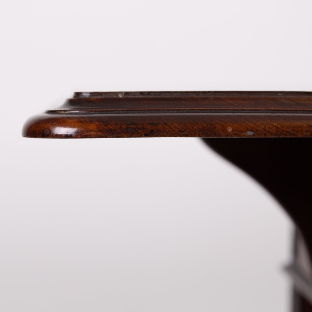 A late nineteenth-century dark mahogany drop-leaf table featuring a single top drawer with a brass pull, two lower open shelves, and fluted legs. View XI