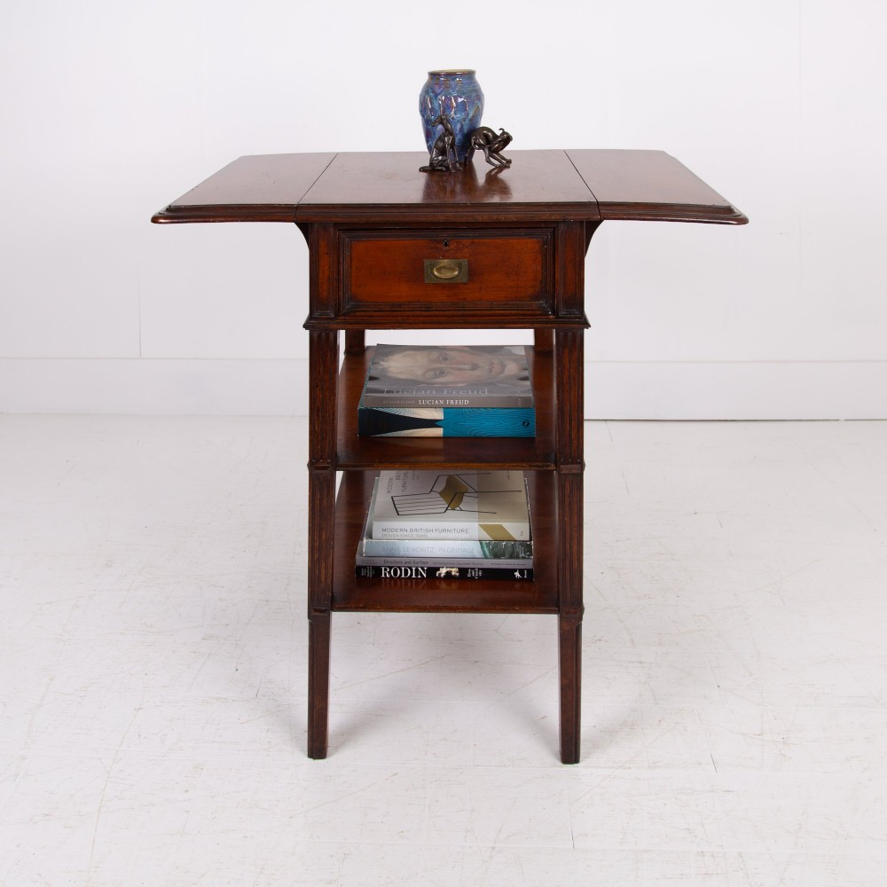 A late nineteenth-century dark mahogany drop-leaf table featuring a single top drawer with a brass pull, two lower open shelves, and fluted legs. View XII