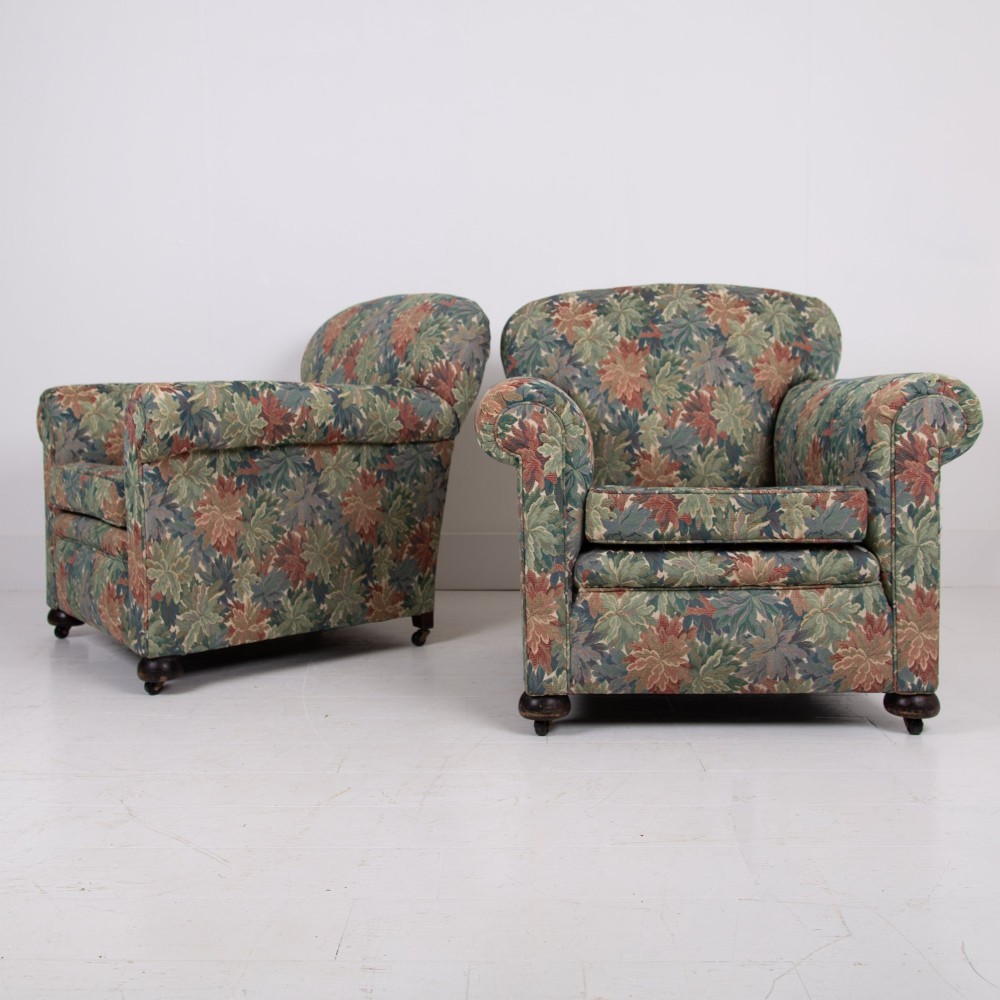 A pair of early 20th-century English upholstered armchairs featuring a multi-coloured botanical leaf pattern, deep seats, rolled arms, and turned feet on castors. View XIV