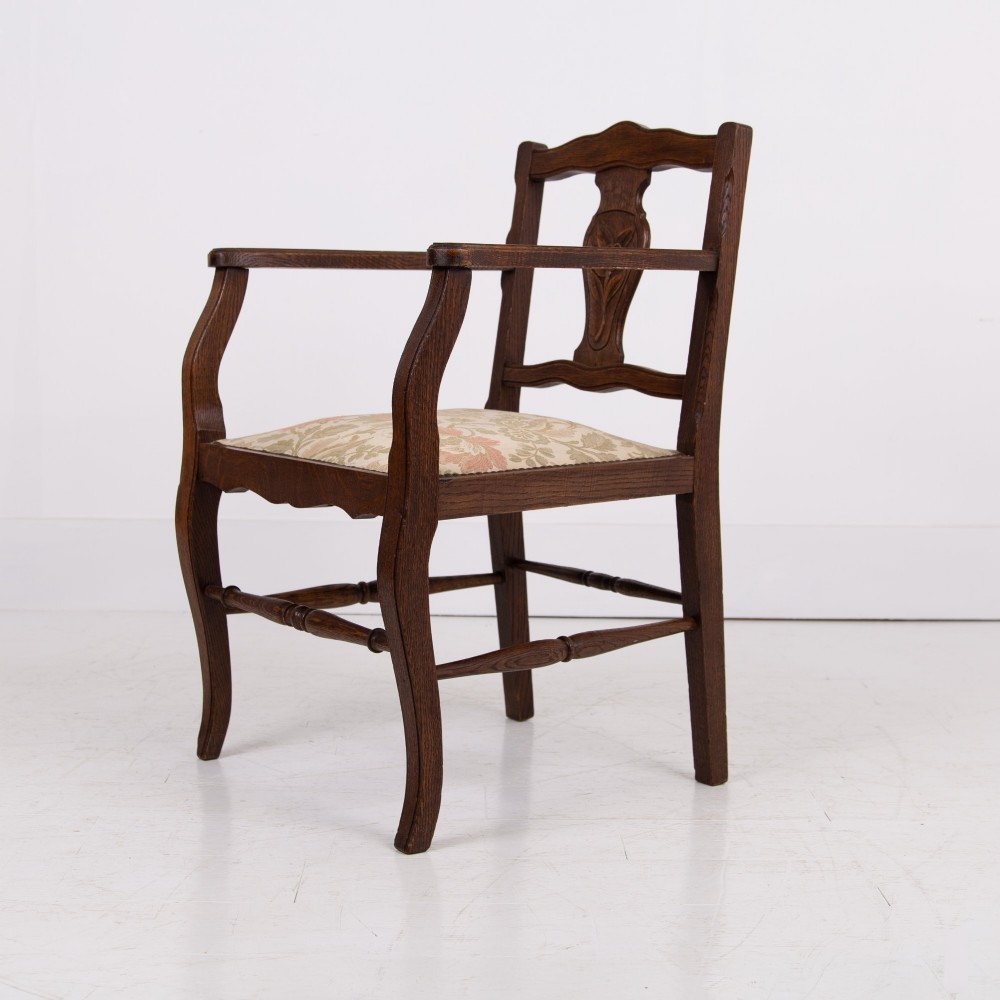 A pair of dark oak open armchairs featuring carved floral back splats, curved arms, turned stretchers, and light floral upholstered seats. View IV