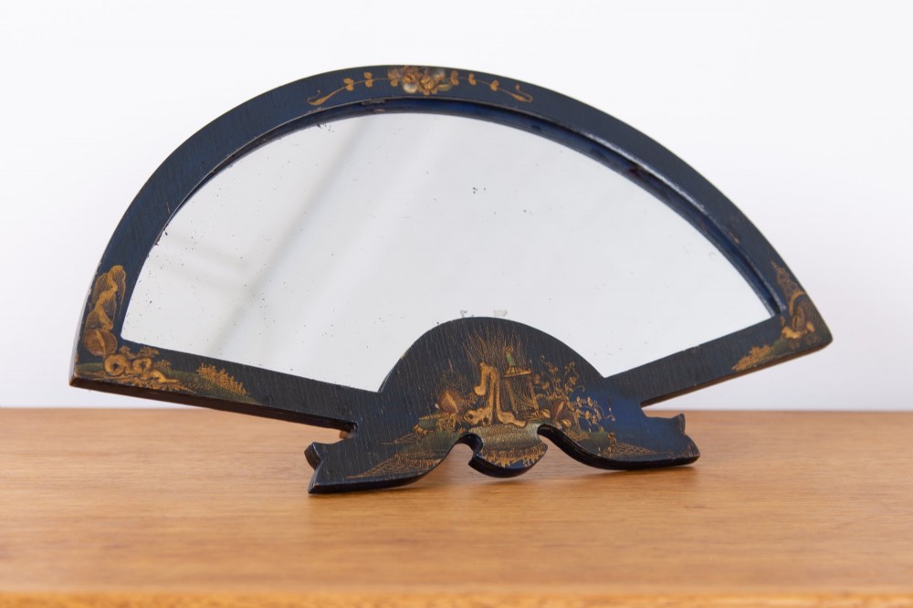 A small fan-shaped tabletop mirror with a black lacquered frame featuring hand-painted gold Chinoiserie detailing. View VII