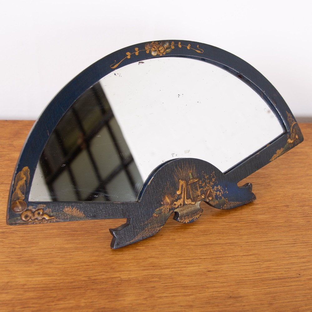 A small fan-shaped tabletop mirror with a black lacquered frame featuring hand-painted gold Chinoiserie detailing. View IX