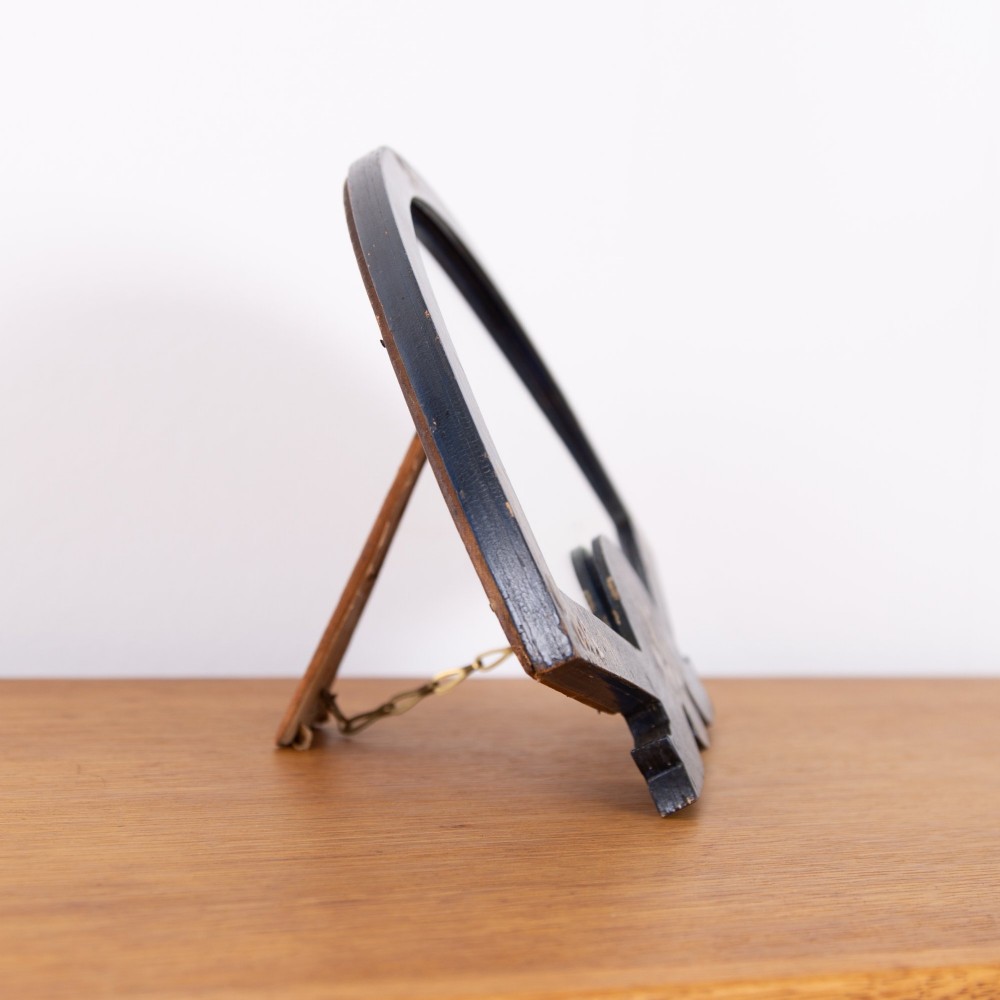 A small fan-shaped tabletop mirror with a black lacquered frame featuring hand-painted gold Chinoiserie detailing. View X
