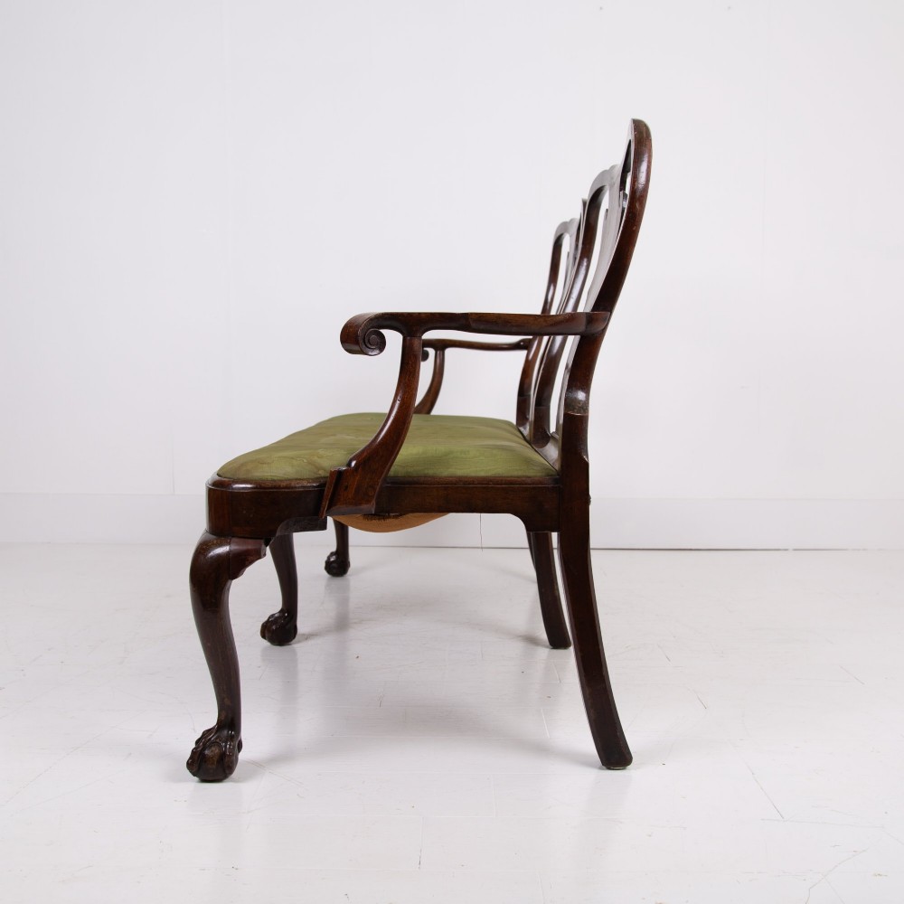 A George II revival double chair-back mahogany settee featuring carved vase splats, cabriole legs with claw and ball feet, and a green upholstered seat. View II