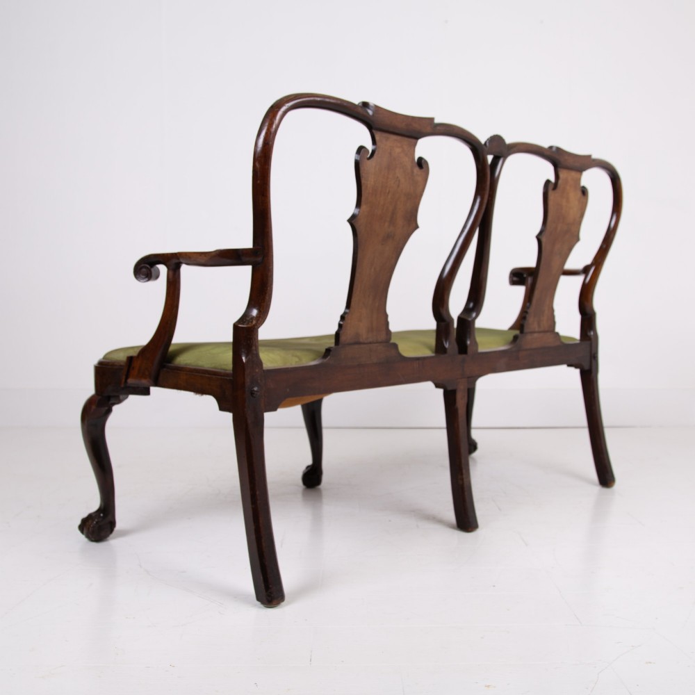 A George II revival double chair-back mahogany settee featuring carved vase splats, cabriole legs with claw and ball feet, and a green upholstered seat. View III