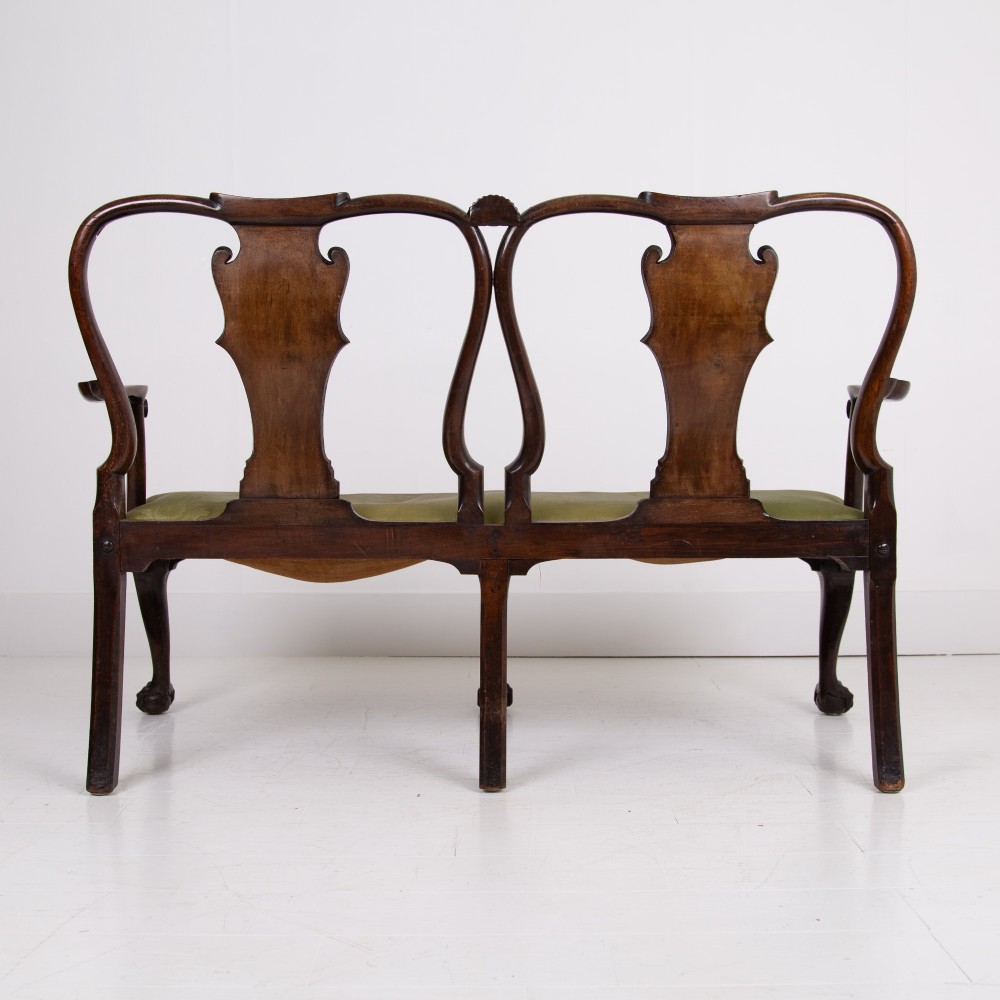 A George II revival double chair-back mahogany settee featuring carved vase splats, cabriole legs with claw and ball feet, and a green upholstered seat. View IV