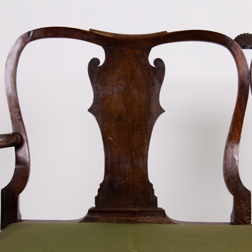 A George II revival double chair-back mahogany settee featuring carved vase splats, cabriole legs with claw and ball feet, and a green upholstered seat. View V