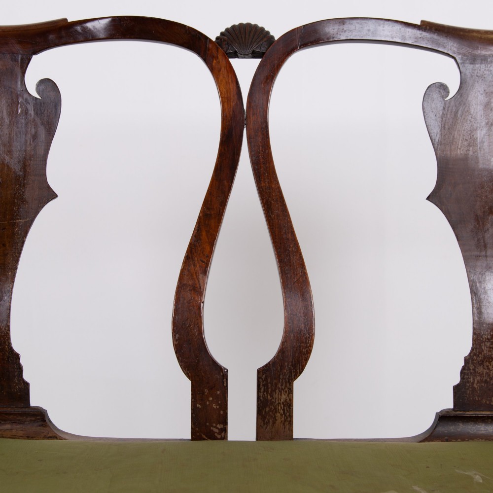 A George II revival double chair-back mahogany settee featuring carved vase splats, cabriole legs with claw and ball feet, and a green upholstered seat. View X