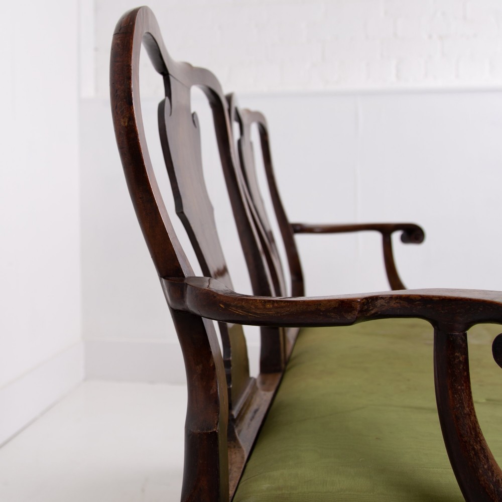 A George II revival double chair-back mahogany settee featuring carved vase splats, cabriole legs with claw and ball feet, and a green upholstered seat. View XIII