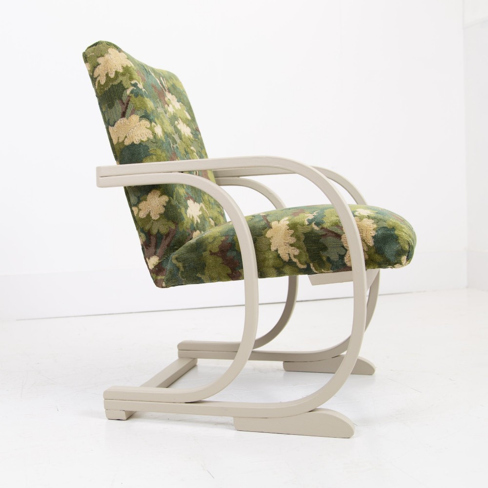 An Art Deco armchair featuring curved off-white painted bentwood arms and frame with green foliage pattern fabric upholstery on the seat and back. View VIII