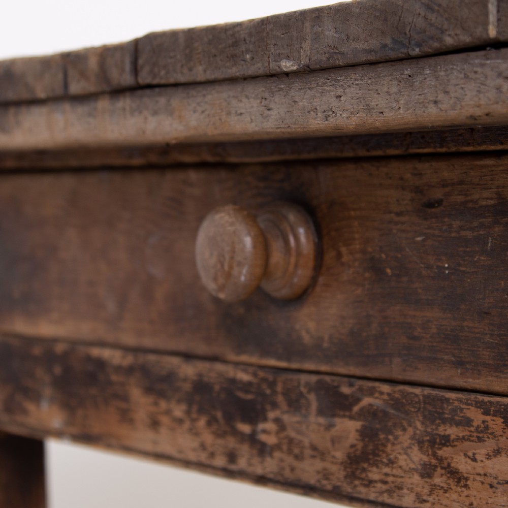 A late Victorian rustic wooden kitchen table featuring turned legs, a single drawer, and a distressed dark finish. View III