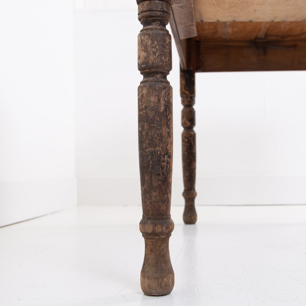 A late Victorian rustic wooden kitchen table featuring turned legs, a single drawer, and a distressed dark finish. View VII