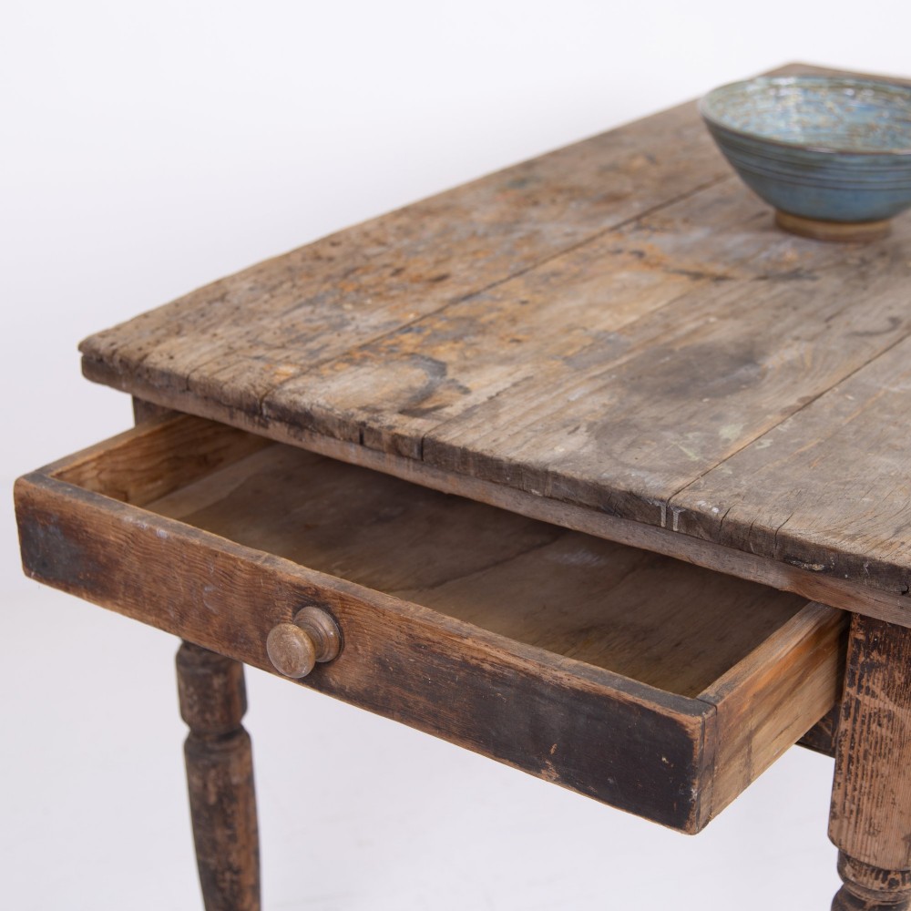 A late Victorian rustic wooden kitchen table featuring turned legs, a single drawer, and a distressed dark finish. View XI