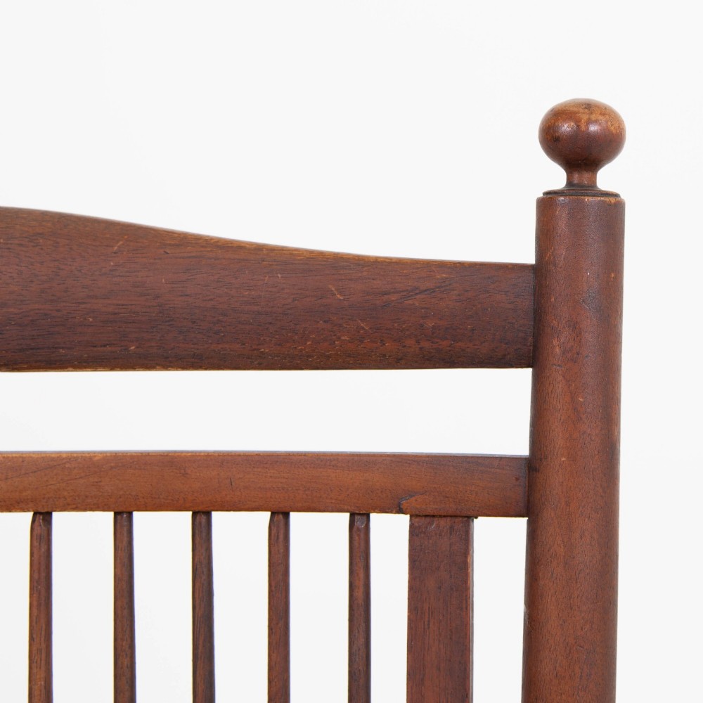 An antique Arts and Crafts wooden armchair featuring turned spindle backrest slats, sloped armrests, turned finials, and a hand-woven natural rush seat. View X