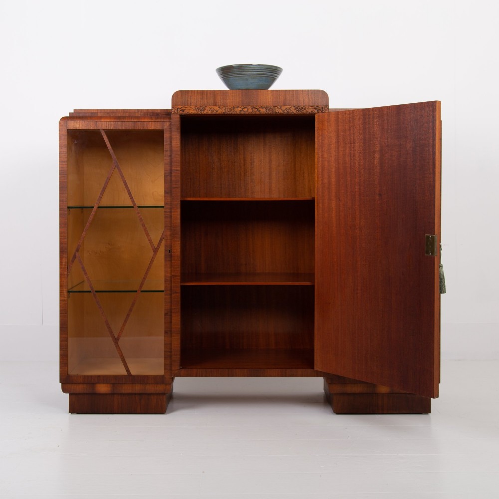 An Art Deco walnut display cabinet featuring a central burr walnut door flanked by two glazed doors with geometric diamond glazing bars. View III